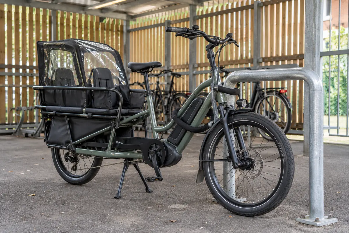 Longtail electric cargo bicycle locked to a fixed anchor in covered storage
