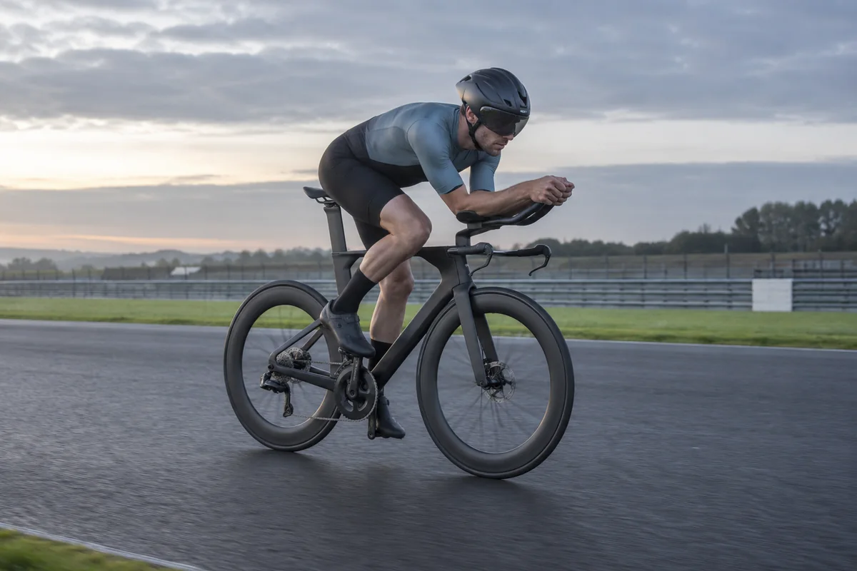 Cyclist using an unbranded time-trial bicycle with aero bars on a closed circuit