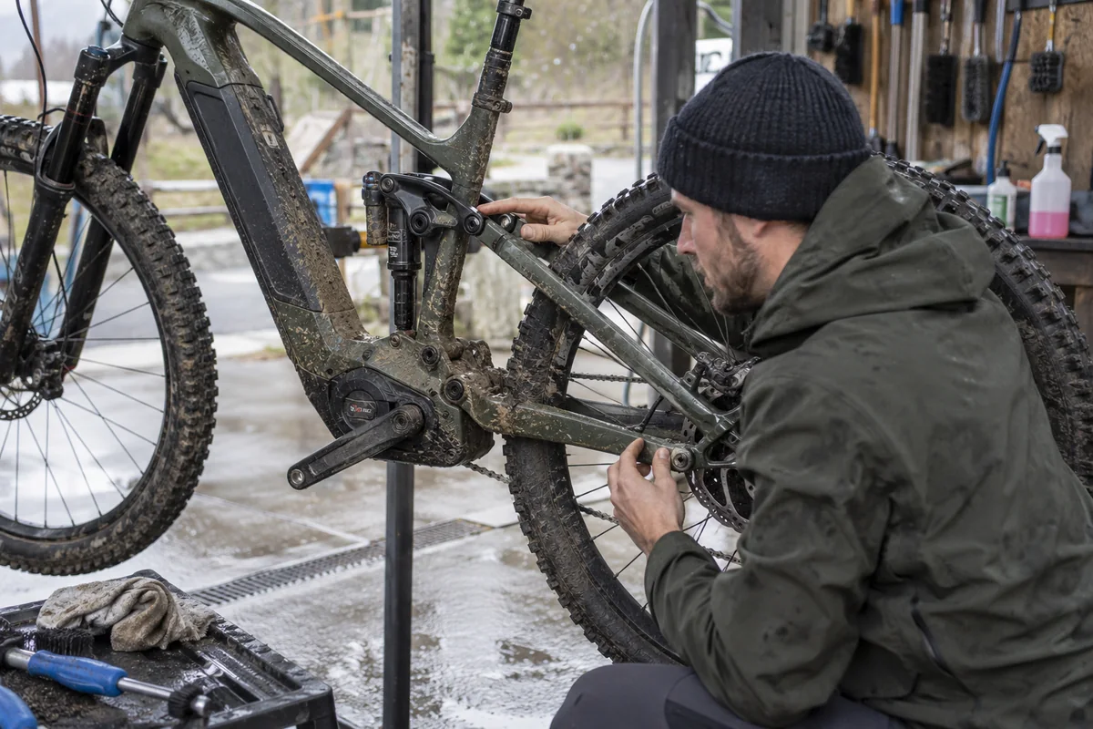 Mechanic checking brake wear, suspension pivots and tyre condition on an electric mountain bicycle